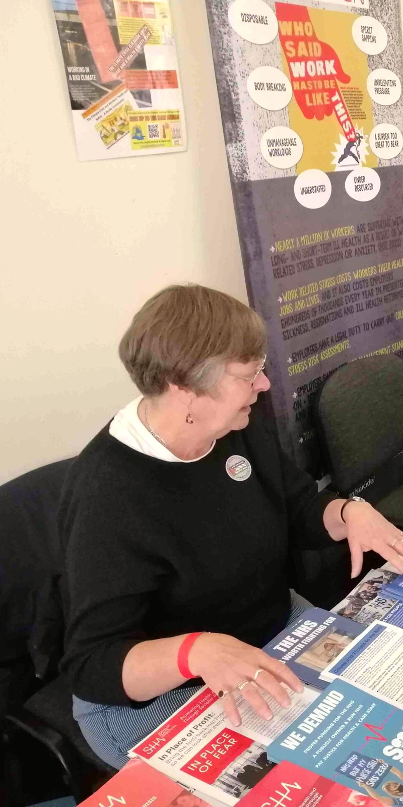 A campaigner smiling at a Hazards stall covered in leaflets
